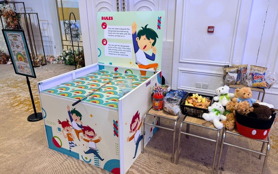 掟彩虹攤位的彩虹目標格、遊戲規則牌與公仔零食獎品