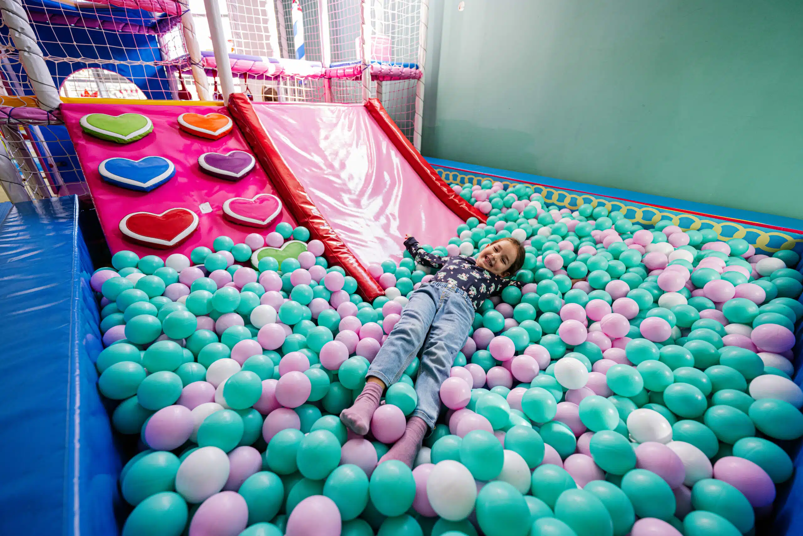 happy-girl-playing-indoor-play-center-playground-lying-color-balls-ball-pool